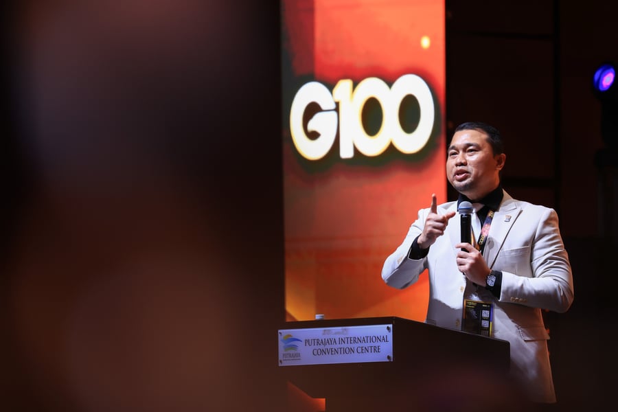 Amanat dan perkongsian inspirasi di hadapan logo rasmi G100