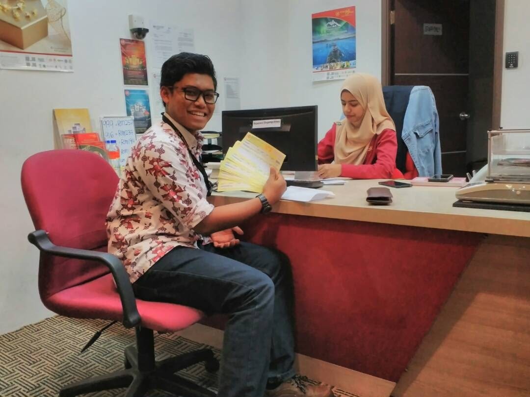 Syarif Jamil (SJ) memegang kipas resit pembelian emas pelanggan di kaunter Public Gold